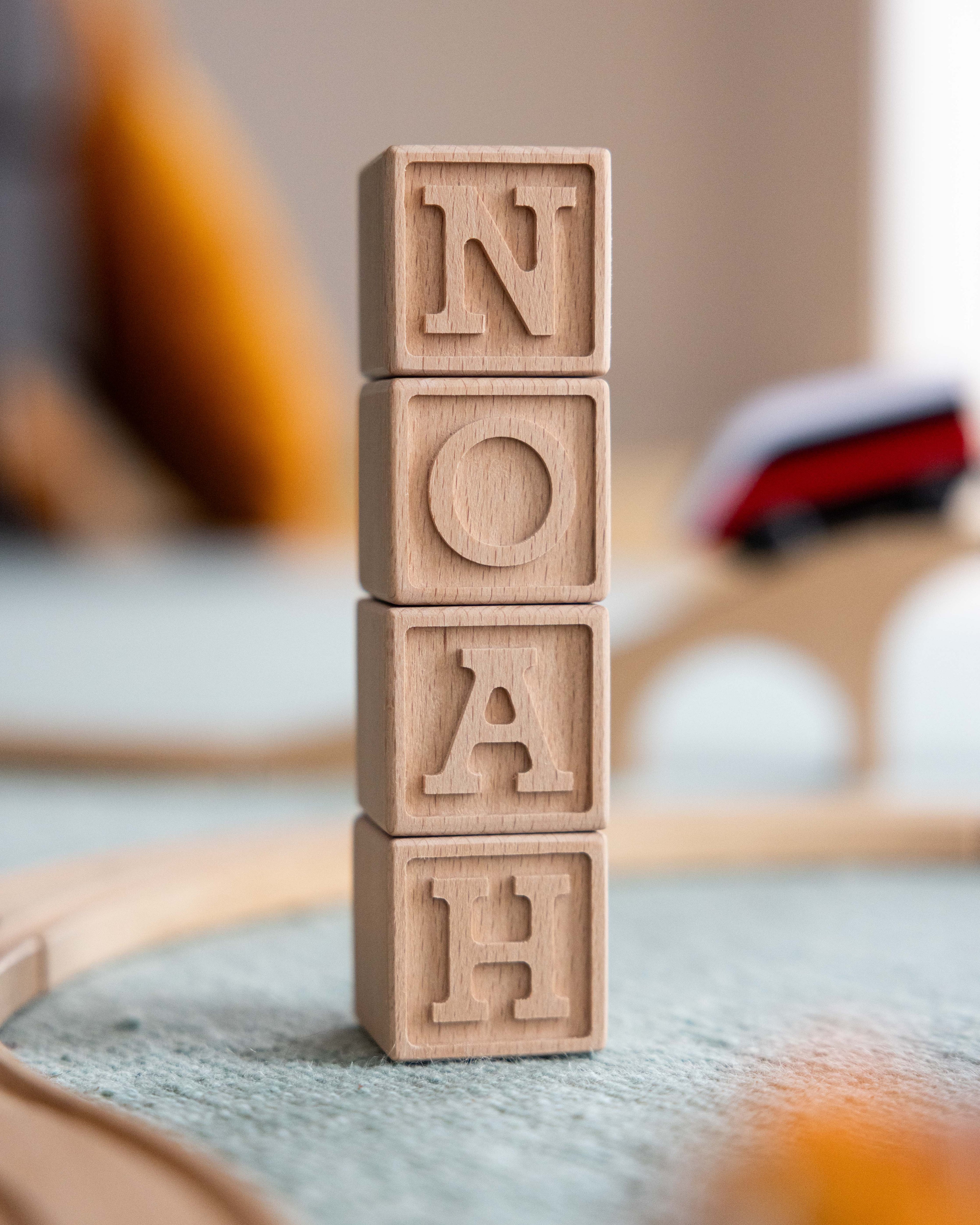 Träklossar namn i trä med bokstäver för barn som bildar namnet Noah