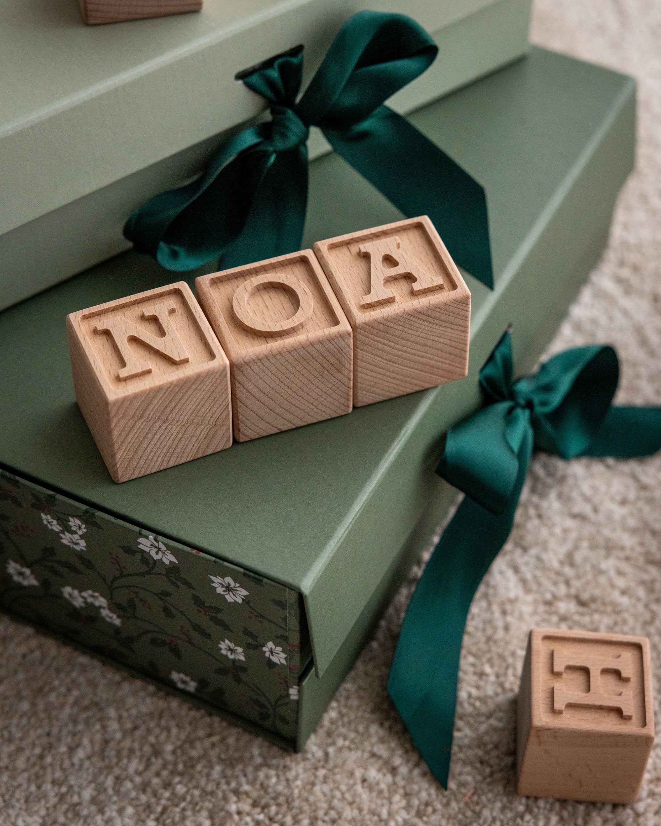 Små bokstavsklossar frästa ur massivt trä som bildar namnet Noa