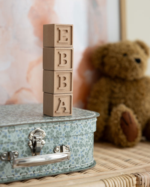 Träklossar med namnet Ebba  i trä med en bokstav på vardera kloss i barnrum